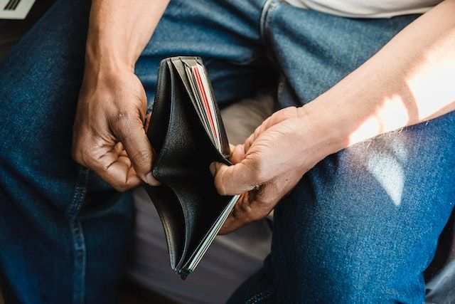 A man holding open his empty wallet
