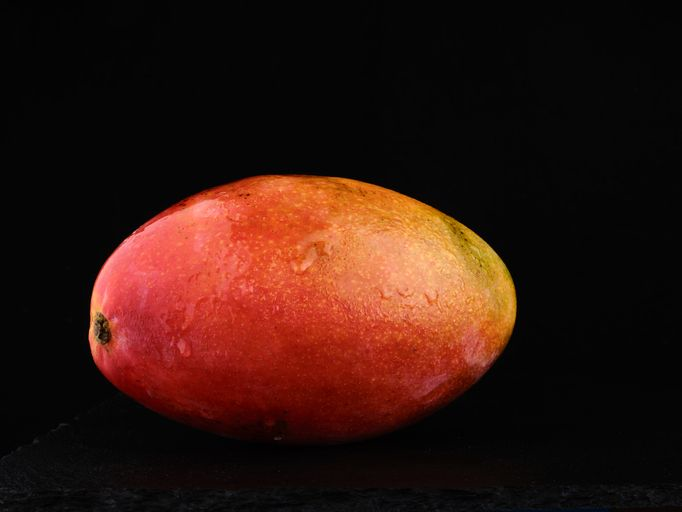 Mango tropical fruit on dark background - stock photo