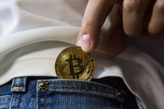 A man putting bitcoin into his pocket. 