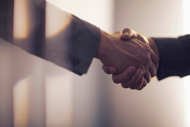 Handshake in contemporary office space - stock photo