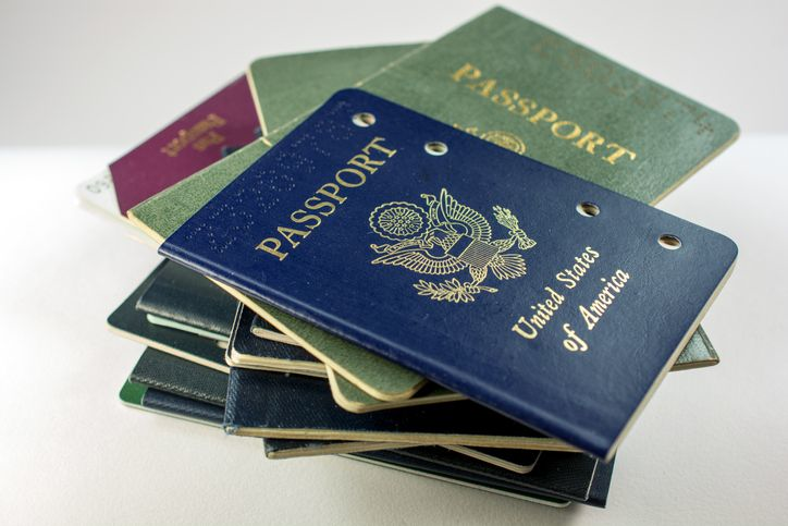 Stack of several old and cancelled passports, primarily USA - stock photo
