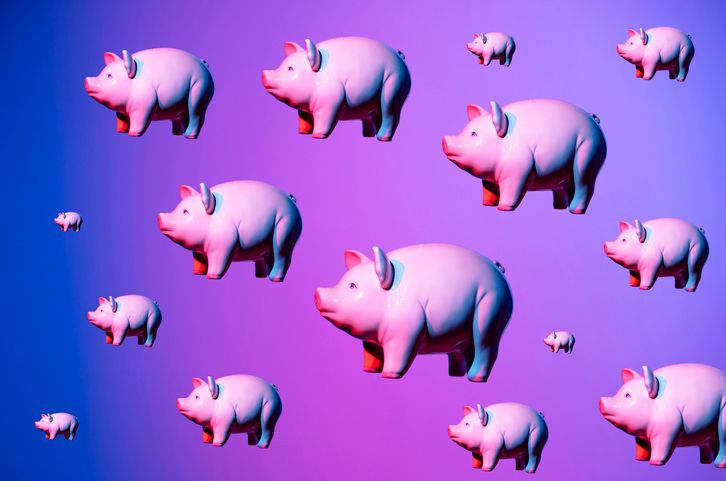 Floating piggy banks in neon light, stock image.