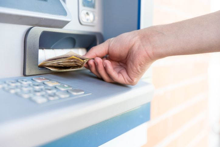Withdraw cash from an ATM - stock photo