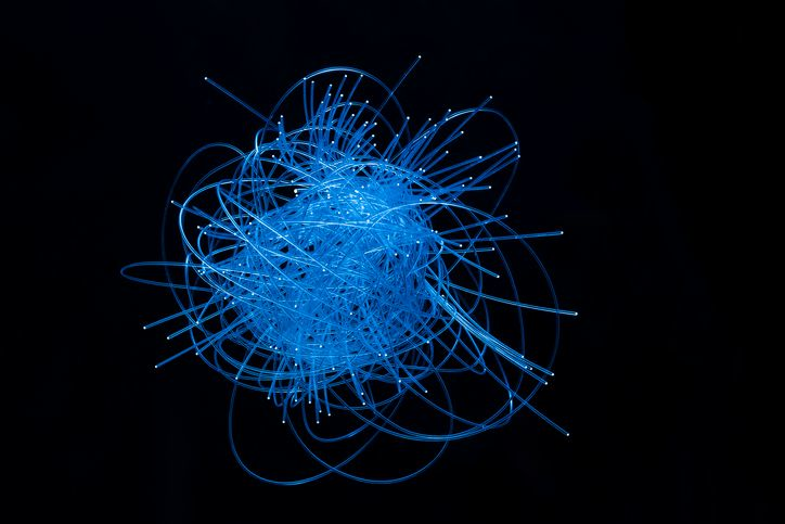 A stock image of an abstract neon art that looks like a tangled thread.