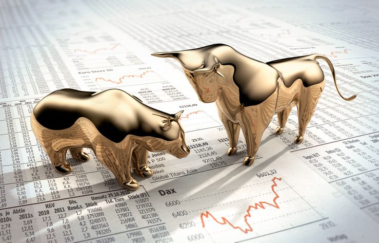 A stock image of metal bear and bull figures over the financial paper. 