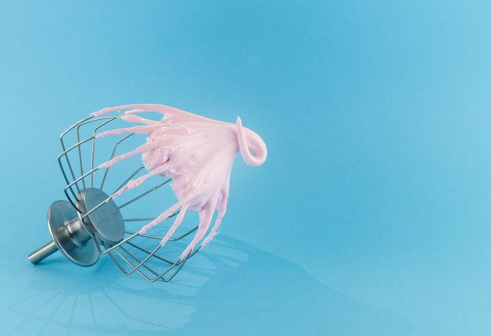 A stock photo featuring an eggwhisk on blue background.