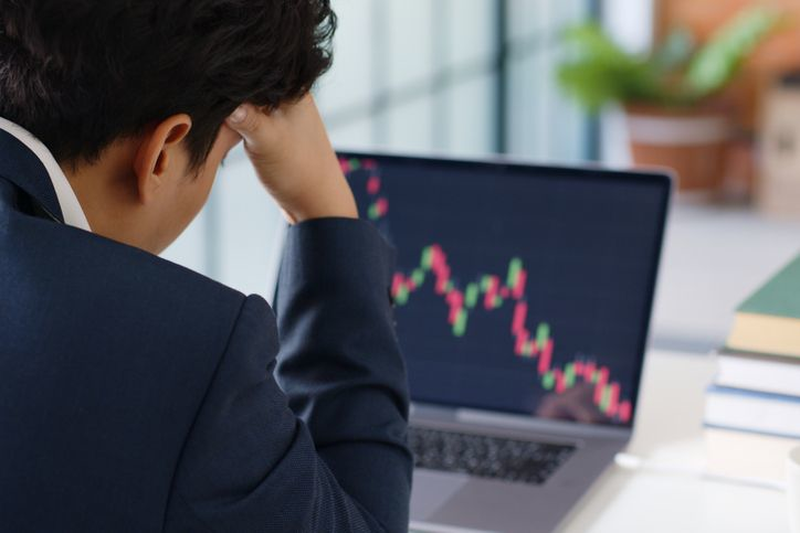 A stock photo featuring stressed trader looking at the candle chart.
