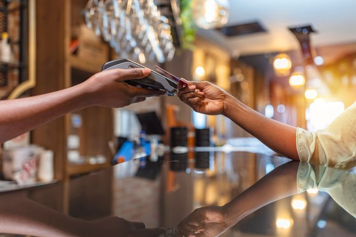 A stock image of a customer paying with a card in the restaurant.