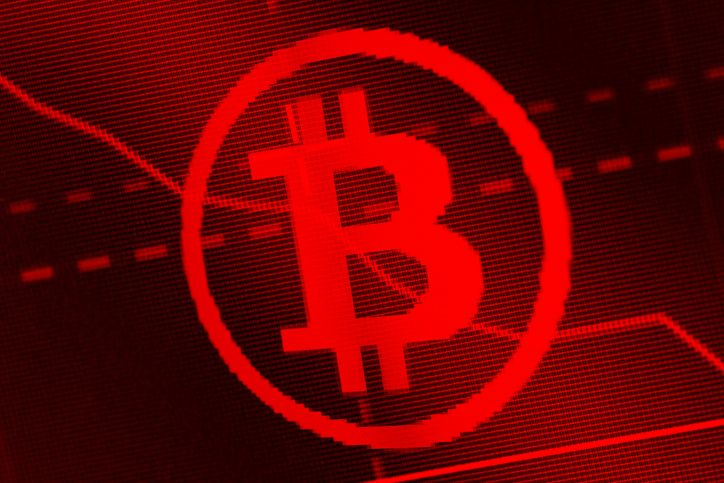 A stock image of pixelated Bitcoin logo on the red background.