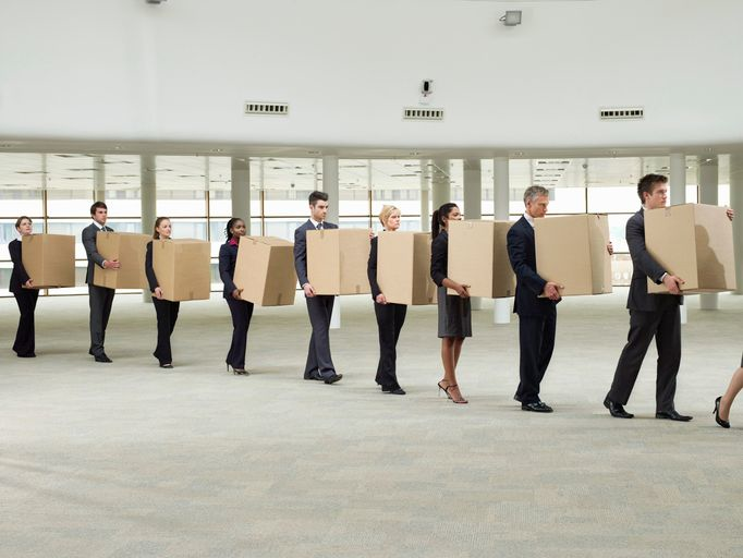 Line of business people carrying cardboard boxes - stock photo