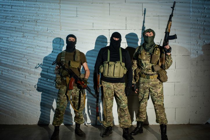 A group of unrecognizable armed men, terrorism concept. 