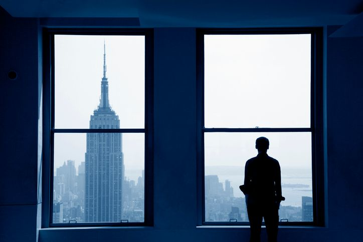 Young man looking out at Manhattan skyline - stock photo