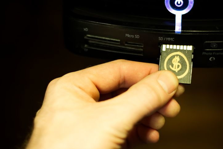 A memory card filled with crypto currency being inserted into a computer.