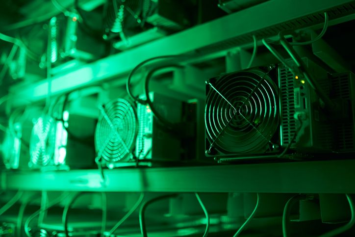A stock photo of a crypto mining rig in green neon light. 
