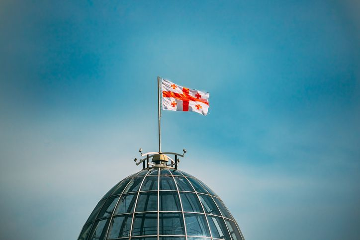 A stock photo of the flag of Georgia waving on the Presidential Palace in Tbilisi, Georgia. 