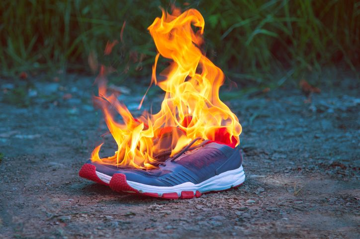 A stock photo of blue running shoes on fire. 