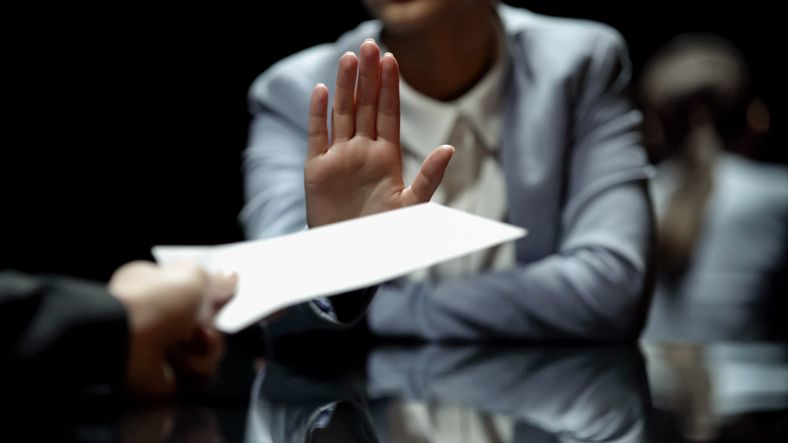 Businesswoman rejecting an offered document with an open hand