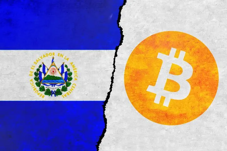 El Salvador and Bitcoin painted flags on a wall with a crack - stock photo. 