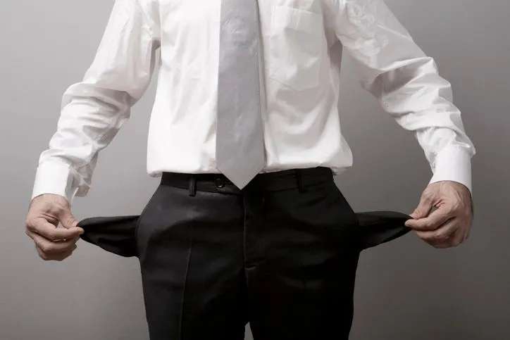 Businessman pulling out his empty pockets, studio shot