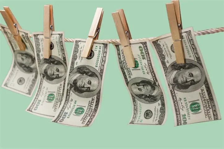 A stock photo featuring five two-dollars bills fixed with the clothes peg. 