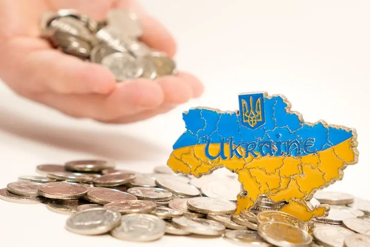 A stock image of Ukraine standing on top of the pile of coins. 