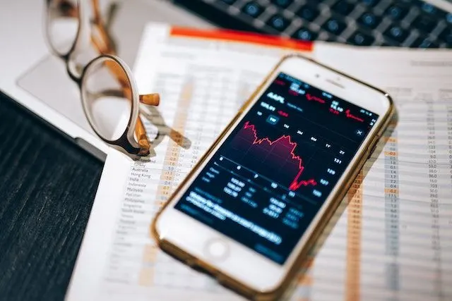 A smartphone with a stock chart in red. 