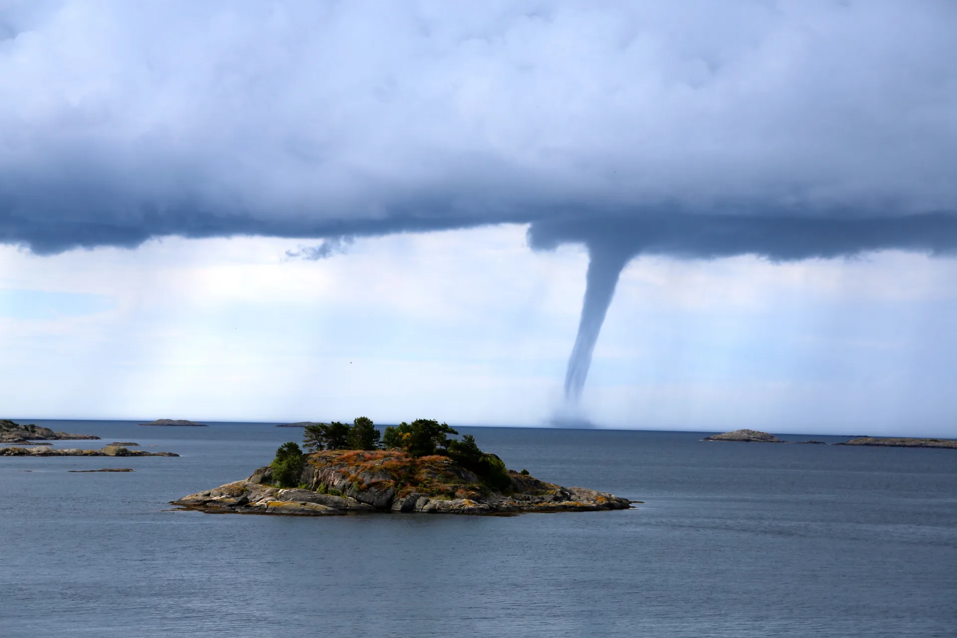 Tornado over the sea with an island