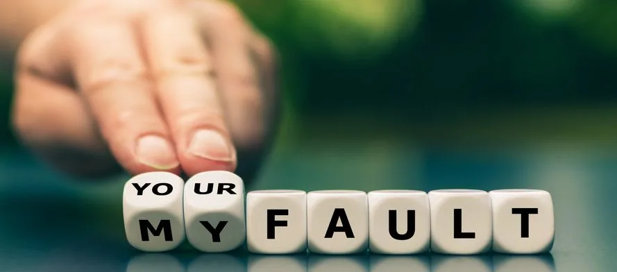 Hand turns dice and changes the expression "my fault" to "your fault". - stock photo