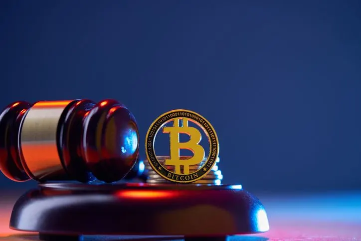 A stock photo of judge's gavel and bitcoin. 