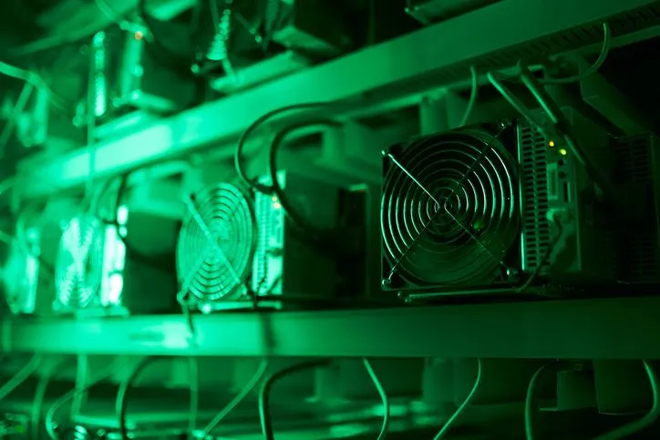 A stock photo of a crypto mining rig in green neon light. 
