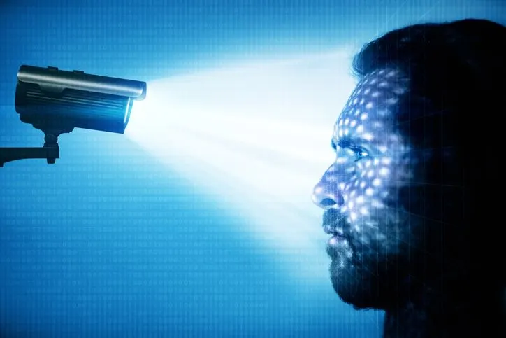 A stock photo of a man staring into a surveillance camera. 