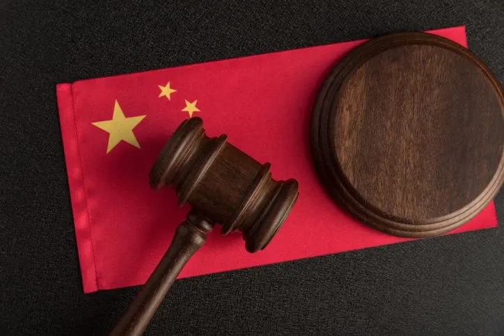 A stock photo of a judge gavel on Chinese flag. 