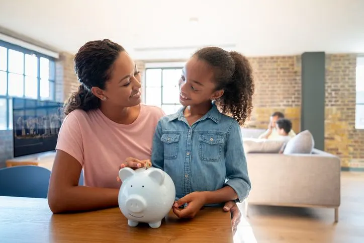 Mother and daughter with a piggy bank