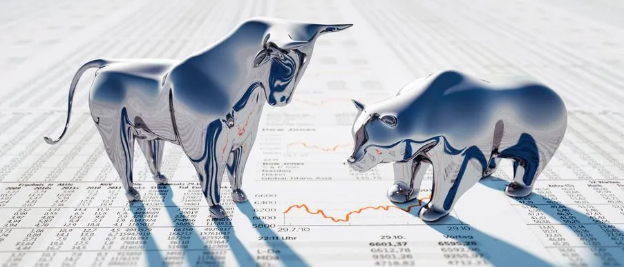 Bull and bear figurines looking at a red chart