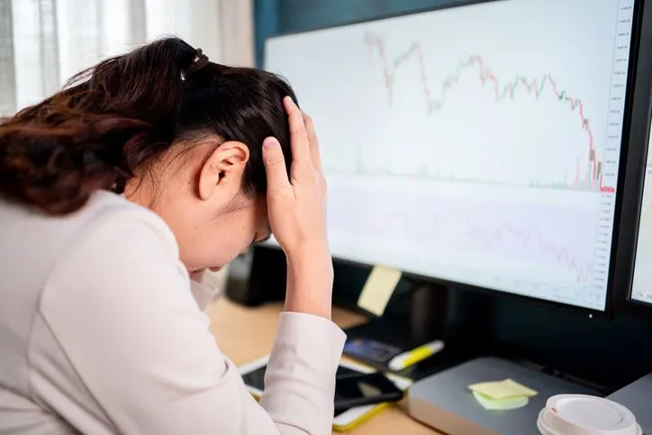 Trader in despair looking away from her screen