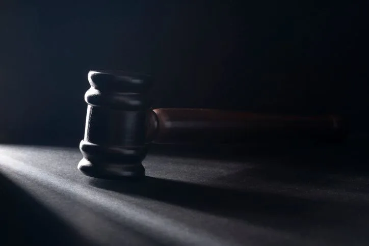 A stock photo of a judge gavel on the black table. 