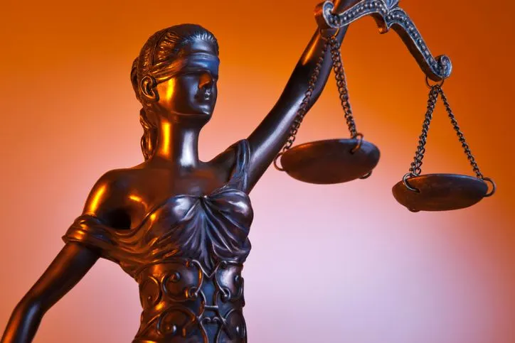 A stock photo of bronze Themes statue on the orange background. 
