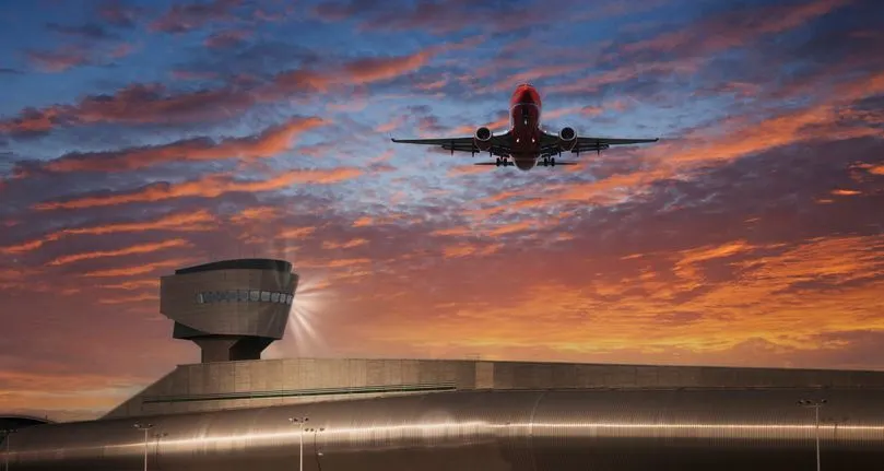 Plane taking off from an airport at sunset