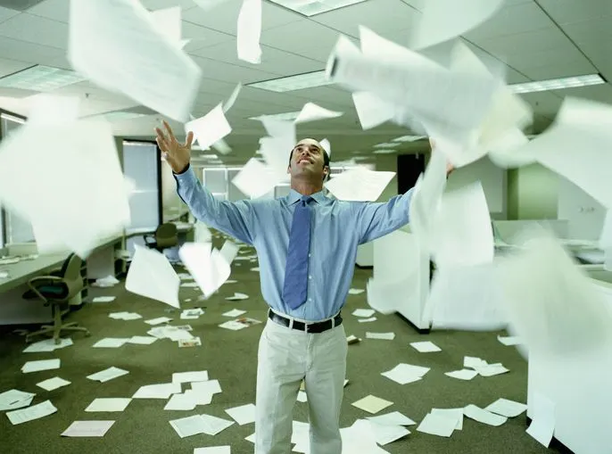 A stock photo of a bankrupt businessmen throwing away paperwork in the office. 