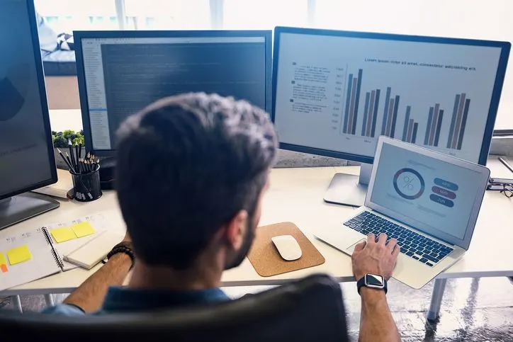 Man working with multiple screens