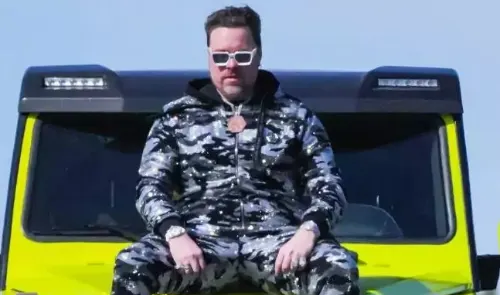 Richard Heart sitting on a car
