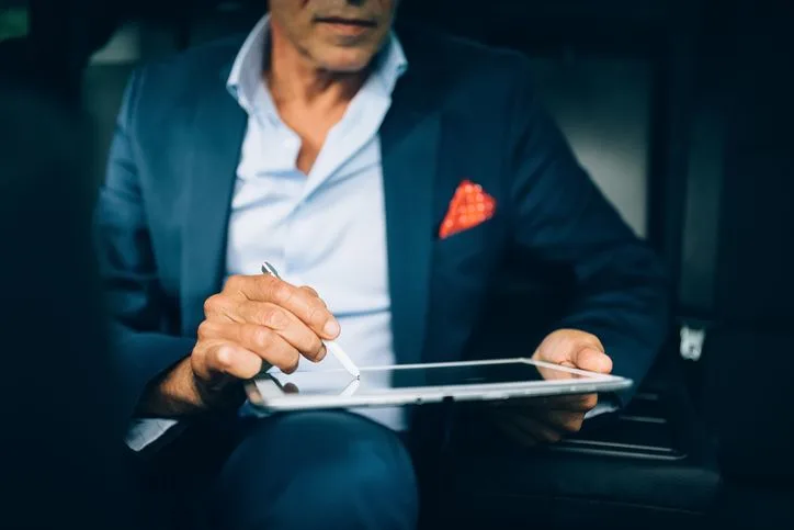 Man in a smart casual outfit signing an e-document on a tablet